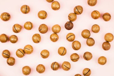 Pembe arka planda soyulmuş macadamia fındığı yok..