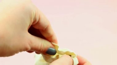 Kadının el ele tutuşup pembe arka planda pamuk torba içinde regl kupasını tutuşu. Sıfır atık alternatif ve çevre dostu kadın hijyen ürünü.