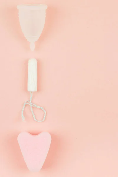 Gros plan sur la coupe menstruelle, le tampon et l'éponge rose Images De Stock Libres De Droits