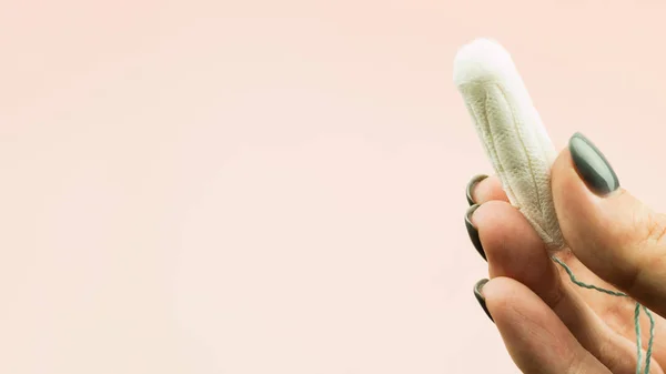 Primer plano de la mano de la mujer sosteniendo la menstruación tampón de algodón —  Fotos de Stock