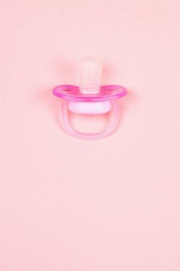 Pembe bebek emziği, pembe arka planda plastik meme ucu olan kukla. Düz yatıyordu. Üst görünüm.