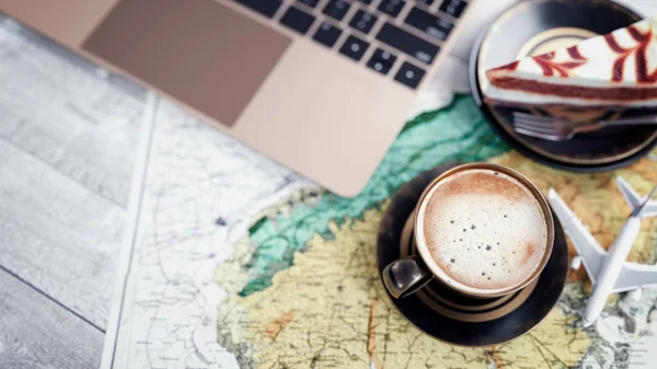 Kávéscsészét, notebookok, sütemények repülőgép és térképek kerülnek a t — Stock Fotó