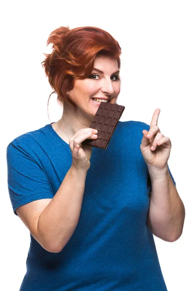 Kurvy žena jíst čokoládu — Stock fotografie