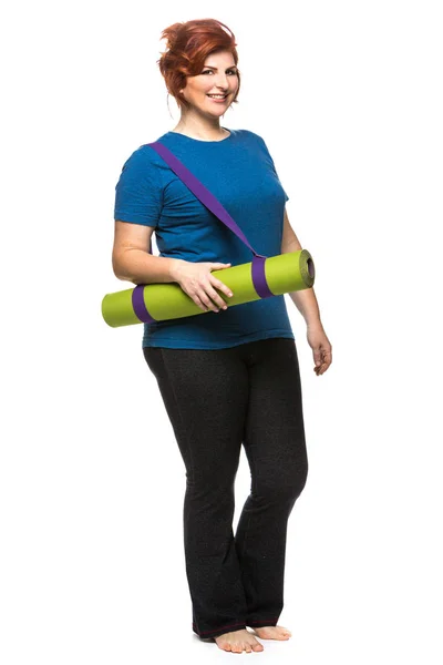 Curvy woman carrying yoga mat Royalty Free Stock Photos