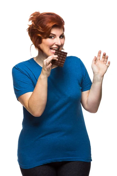 Curvy woman eating chocolate Royalty Free Stock Images