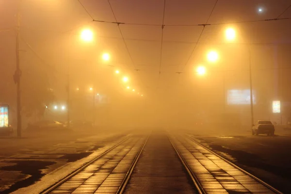 Gece saatlerinde şehirde tramvay raylarında yoğun sis var. Işıklar sarı-124; EKATERINBURG, RUSSIA - 18 Temmuz 2013.