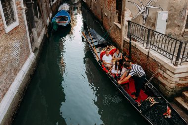 Gondolcu, turistleri karaya çıkarmak için siyah bir gondol park etti. VENICE, İtalya - 16 EPTEMBER 2018. 