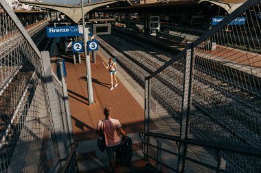 Tren istasyonunun en üst görüntüsü ve 124 numaralı treni bekleyen insanlar; BOLOGNA, İtalya - 17 Eylül 2018.