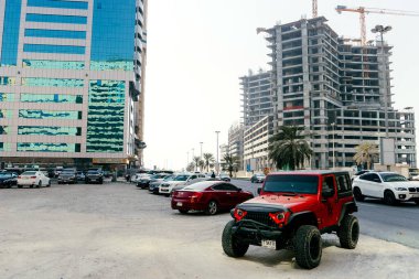 Şeriat 'ta kaldırımda 4x4' lük bir pasaport ile kırmızı bir cip park edilmiş; BİRLİK ARAB EMIRATES, SHARJAH - 17 Ekim 2017.