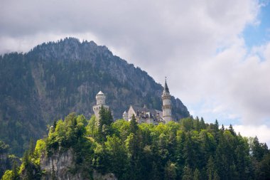 Ortaçağ castle Neuschwanstein. Mavi gökyüzü ve Alpler çevresinde