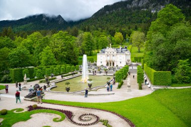 Ettal, Almanya - 5 Haziran 2016: Linderhof Sarayı. Merkezi kompleksinin ana, Kuzey-Güney ekseni görünümünü. Çeşme grup Flora ve puttos ön planda üzerinde. Bavyera, Almanya.