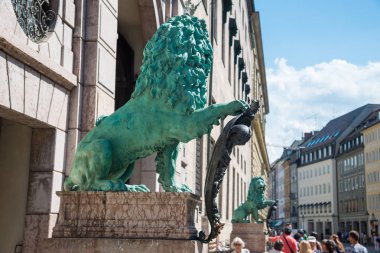 Münih, Almanya - 7 Haziran 2016: Odeonplatz 'daki Münih Alte Residenz Sarayı' nda Bavyera aslan heykeli. Münih, Bavyera, Almanya. Münih, Almanya 'nın Bavyera eyaletinin başkenti ve en büyük şehridir.