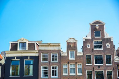 Tipik eski evler Amsterdam, Hollanda mavi gökyüzü altında.