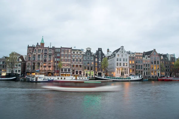 View of typical Amsterdam houses along canal on cloudy sky. — Stock Photo, Image