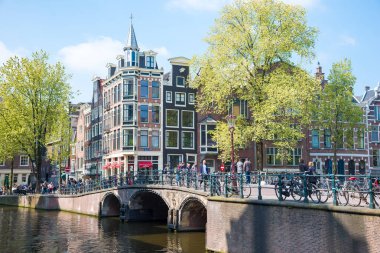 Amsterdam, Hollanda - 20 Nisan 2017: Köprüler ve tipik Hollanda evleri ile Amsterdam kanallarının güzel manzarası. Hollanda, Hollanda. Turistlerin gözlerine güzel manzaralar.