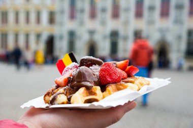Geleneksel Belçikalı tatlı-waffle ile çilek ve krem arka planda Brugge, Belçika