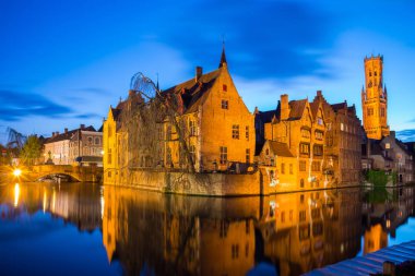 Bruges, Belçika - 17 Nisan 2017: Rosary Rıhtımı - Rozenhoedkaai ve Belfry Alacakaranlıkta. Bruges, Belçika 'daki bir ortaçağ peri masalından bir sahne
