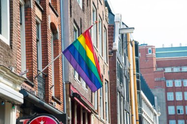 Amsterdam 'ın tarihi şehir merkezinde bir sokakta Gay Pride gökkuşağı bayrağı. Avrupa 'nın en romantik ve güzel şehirlerinden biridir..