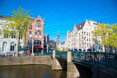 Amsterdam, Hollanda-20 Nisan 2017: Kanal, köprüler, Bisikletler ve turistler ile Amsterdam 'ın panoramik şehir manzarası