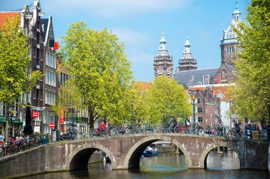 Amsterdam, Hollanda - 20 Nisan 2017: Köprü, kanal ve St. Nicolas Church Amsterdam'da. Amsterdam Hollanda'nın başkenti ve en kalabalık olduğunu