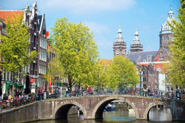 Amsterdam, Hollanda - 20 Nisan 2017: Köprü, kanal ve St. Nicolas Church Amsterdam'da. Amsterdam Hollanda'nın başkenti ve en kalabalık olduğunu