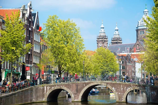 Amsterdam, Hollanda - 20 Nisan 2017: Köprü, kanal ve St. Nicolas Church Amsterdam'da. Amsterdam Hollanda'nın başkenti ve en kalabalık olduğunu