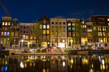Amstel Nehri, kanallar ve gece manzarası güzel Amsterdam şehir. Hollanda.