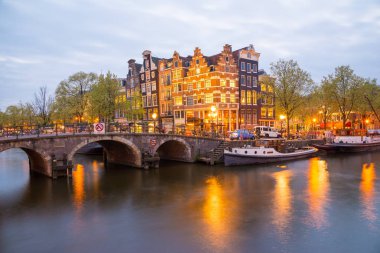 Amsterdam Kanalı, Köprü ve tipik evler, tekneler ve bisikletler Alacakaranlık mavi saatinde, Hollanda, Hollanda.