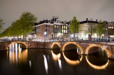 Amsterdam kanalları ve gece boyunca onları bentleri görünümü.