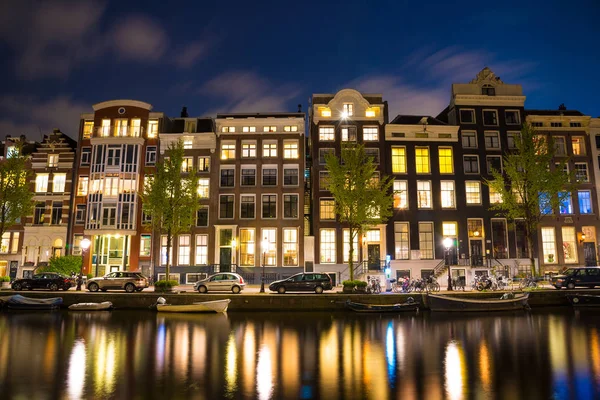 Amsterdam'da güzel bir gece. gece aydınlatma bina ve su kanalına yakın tekneler.