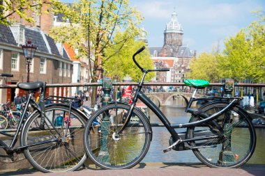 Amsterdam, Hollanda - 20 Nisan 2017: Şehir sokak Nehri Kanal Köprüsü Amsterdam'da bisikletle