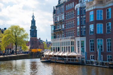 Amsterdam, Hollanda - 19 Nisan 2017: Tipik evleri, kilise, köprü ve Amsterdam'da mavi gökyüzü ile geniş kanal. Büyük kültürel etkinlik, zarif kanallar ve köprüler.