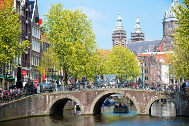 Amsterdam, Hollanda - 20 Nisan 2017: Köprü, kanal ve St. Nicolas Church Amsterdam'da. Amsterdam Hollanda'nın başkenti ve en kalabalık olduğunu