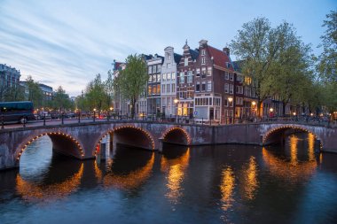 Amsterdam'da güzel bir gece. gece aydınlatma bina ve su kanalına yakın tekneler.