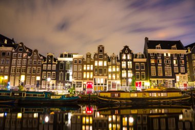 Amsterdam'da güzel bir gece. gece aydınlatma bina ve su kanalına yakın tekneler.