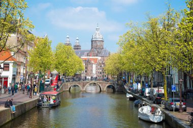 Amsterdam, Hollanda - 20 Nisan 2017: Amsterdam kanalları ve köprü, tekneler ve tipik Hollanda evleri ile harika manzara. Holland, Hollanda. Tabii ki turistler için güzel kez bakıldı.
