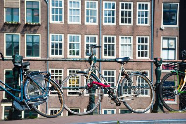 Amsterdam, Hollanda - 20 Nisan 2017: Şehir sokak Nehri Kanal Köprüsü Amsterdam'da bisikletle.