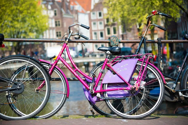 Purple bicycle on the bridge in Amsterdam, Netherlands.