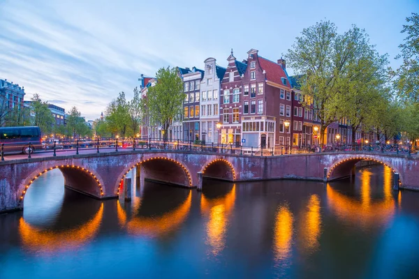 Meşhur Amstel nehri ve güzel Amsterdam şehrinin gece manzarası. Hollanda.