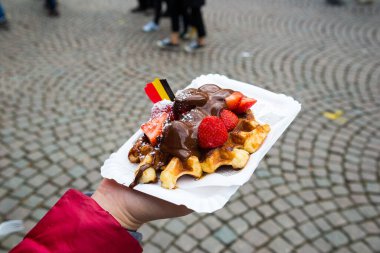 Çikolata soslu ve çilekli Belçika waffle 'ı, Bruges şehrinin arka planı, Belçika.