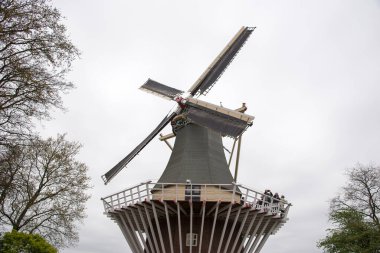 Keukenhof, Amsterdam, Hollanda 'daki ünlü bahçede birçok insanın olduğu eski bir yel değirmeni.
