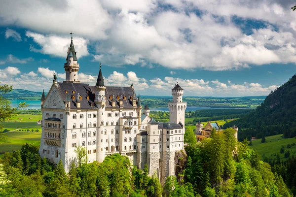 Medieval castle Neuschwanstein. Around the blue sky and the Alps. Beautiful view of the castle. Open landmark and background nature.