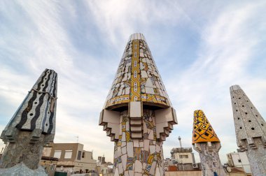 Barcelona, İspanya - 20 Eylül 2014: Guell Sarayı 'nın çatısı tasarımı - Gaudi Chimney: kırık fayans mozaikleri ve garip dekore edilmiş bacalar ilk çalışmalarında açıkça görülmektedir..