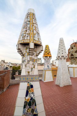 Barcelona, İspanya - 20 Eylül 2014: Guell Sarayı 'nın çatısı tasarımı - Gaudi Chimney: kırık fayans mozaikleri ve garip dekore edilmiş bacalar ilk çalışmalarında açıkça görülmektedir..