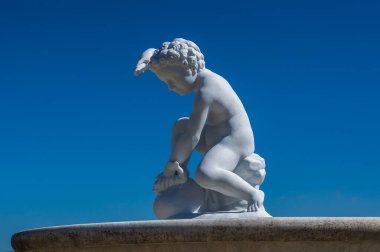 Balık öldüren kıvırcık saçlı gencin beyaz heykeli. Boboli Bahçeleri, Floransa, Toskana, İtalya.