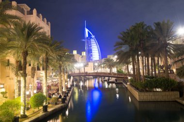 DUBAI, BAE - 19 Kasım 2019 'da Dubai, BAE' deki Madinat Jumeirah bölgesinden Burj al Arab Hotel 7 yıldızının gece görüşü.