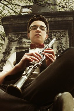 hipster oturan adam klarnet çalıyor 