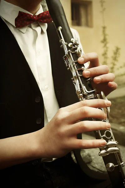 Сидящий хипстер играет на кларнете — стоковое фото