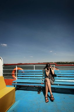 Güverte üzerinde oturan kadın hipster 