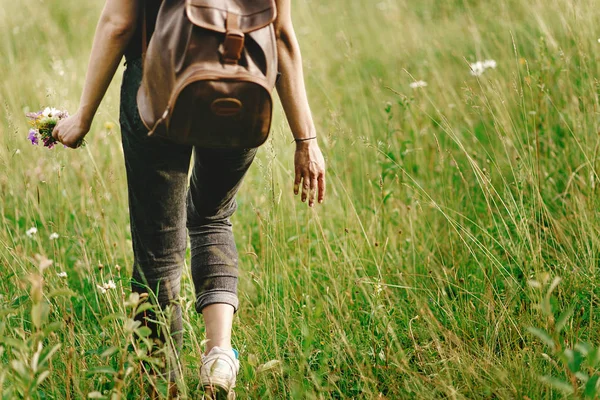 Hipster kvinna promenader i gräs — Stockfoto